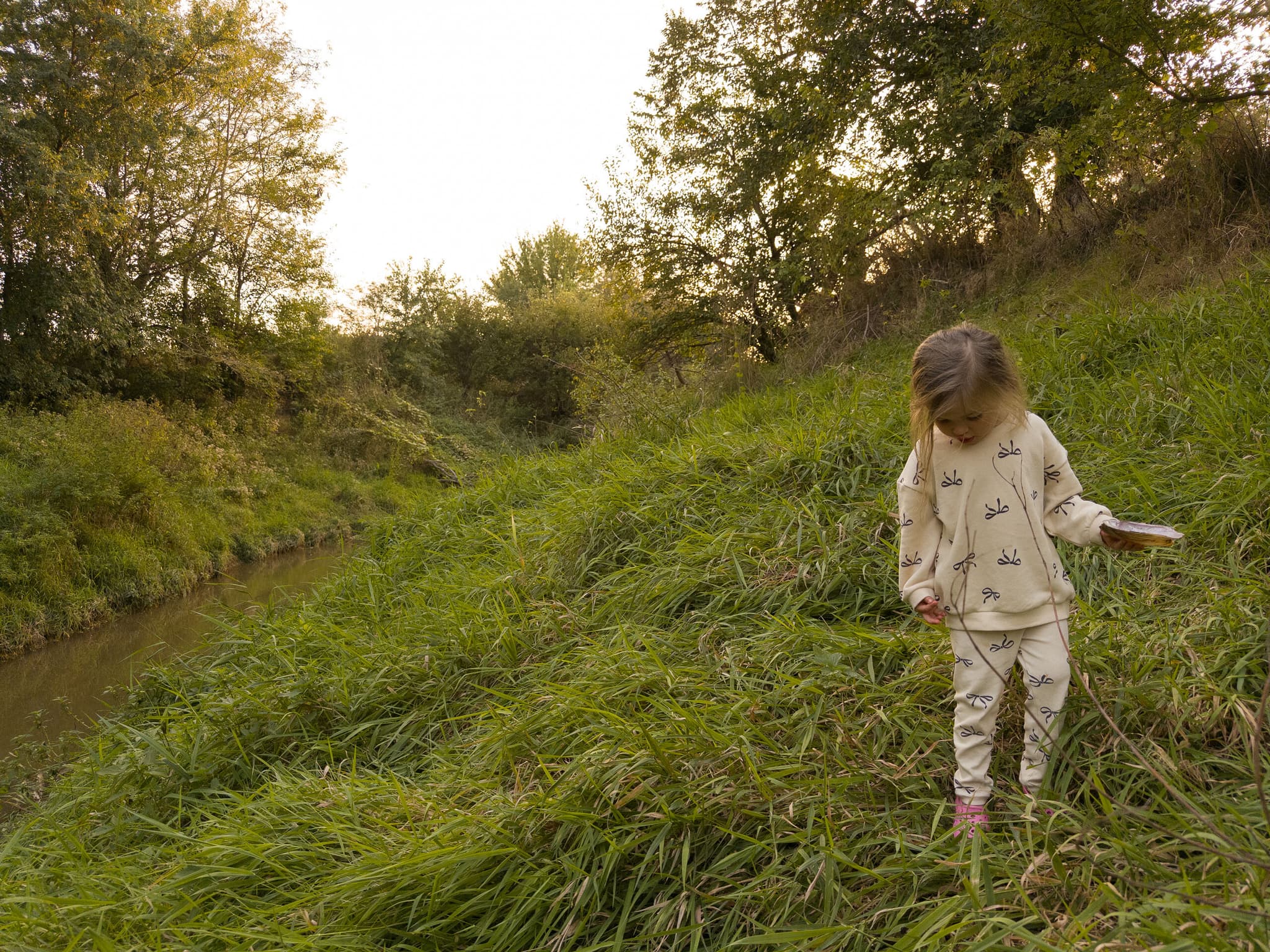My daughter holding a shell along the creek that runs through the property.